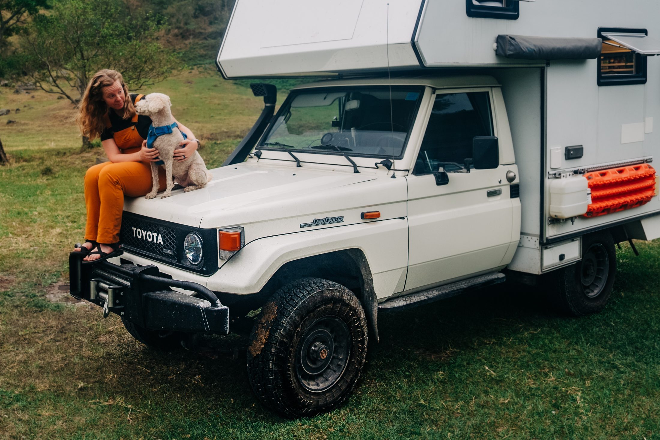 Sara and Kramer sitting on the hood of the Land Cruiser