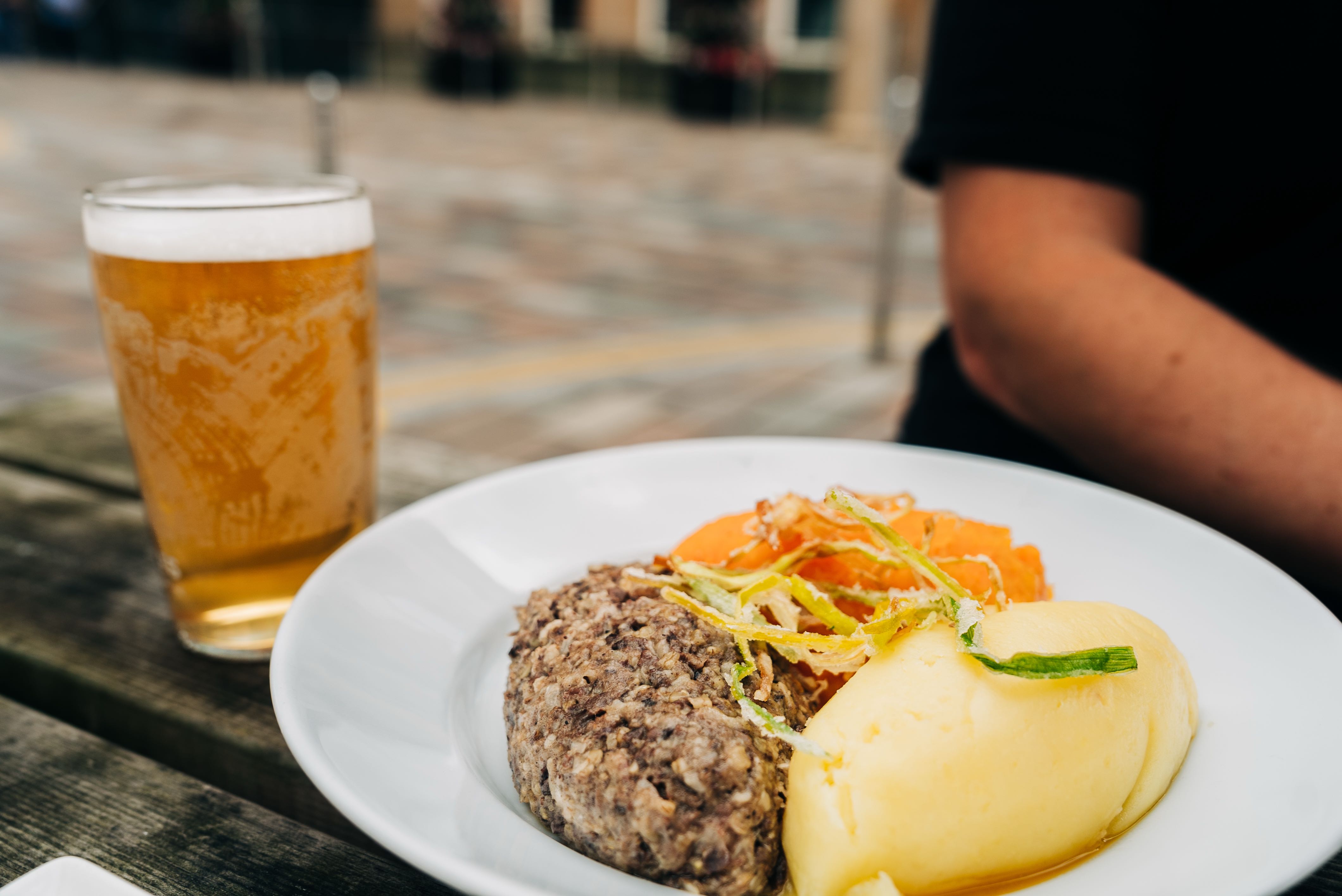 Scottish haggis served with neeps and tatties and a beer