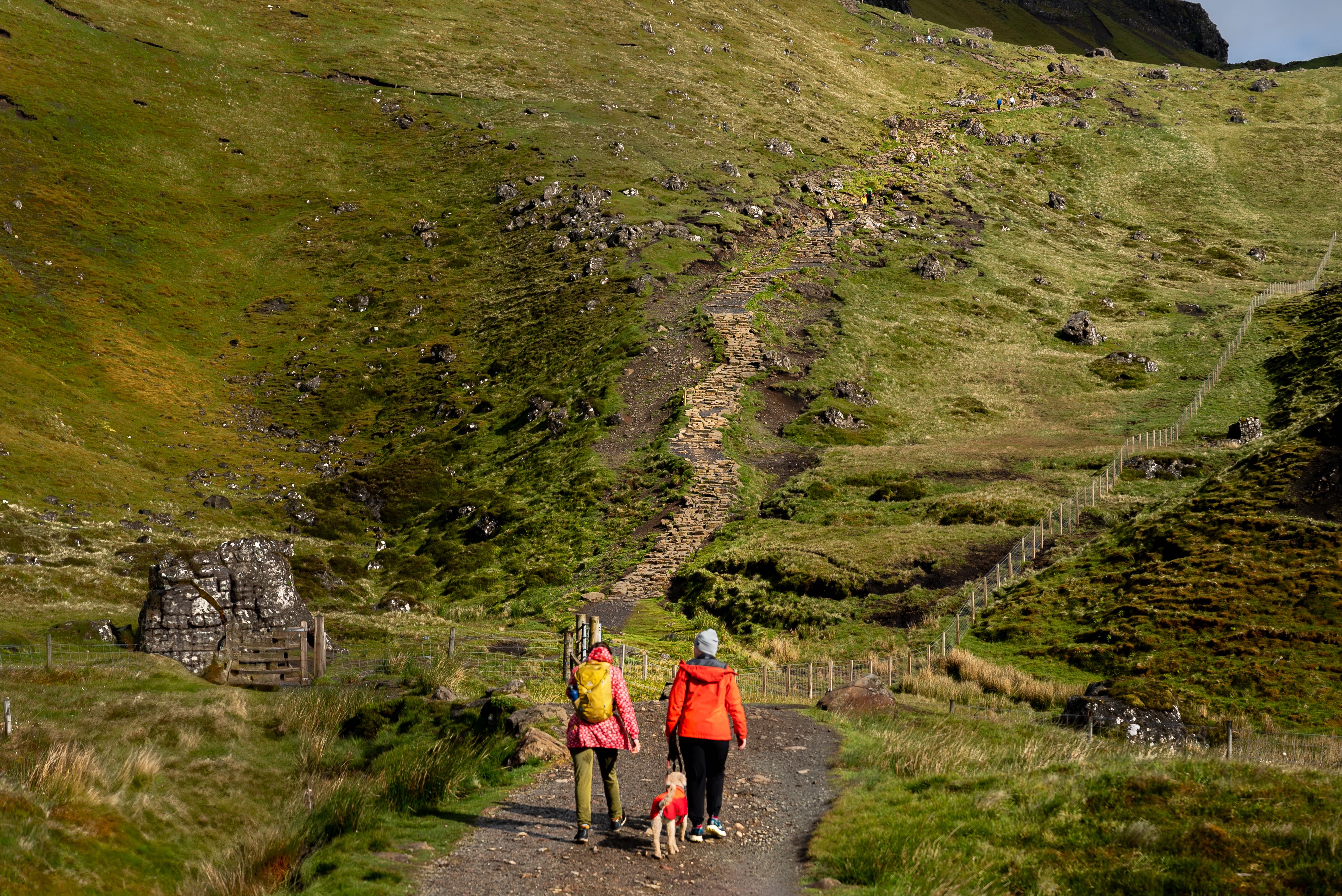 Two girls and a dog begin hike up Old Man of Storr on the Isle of Skye, Scotland