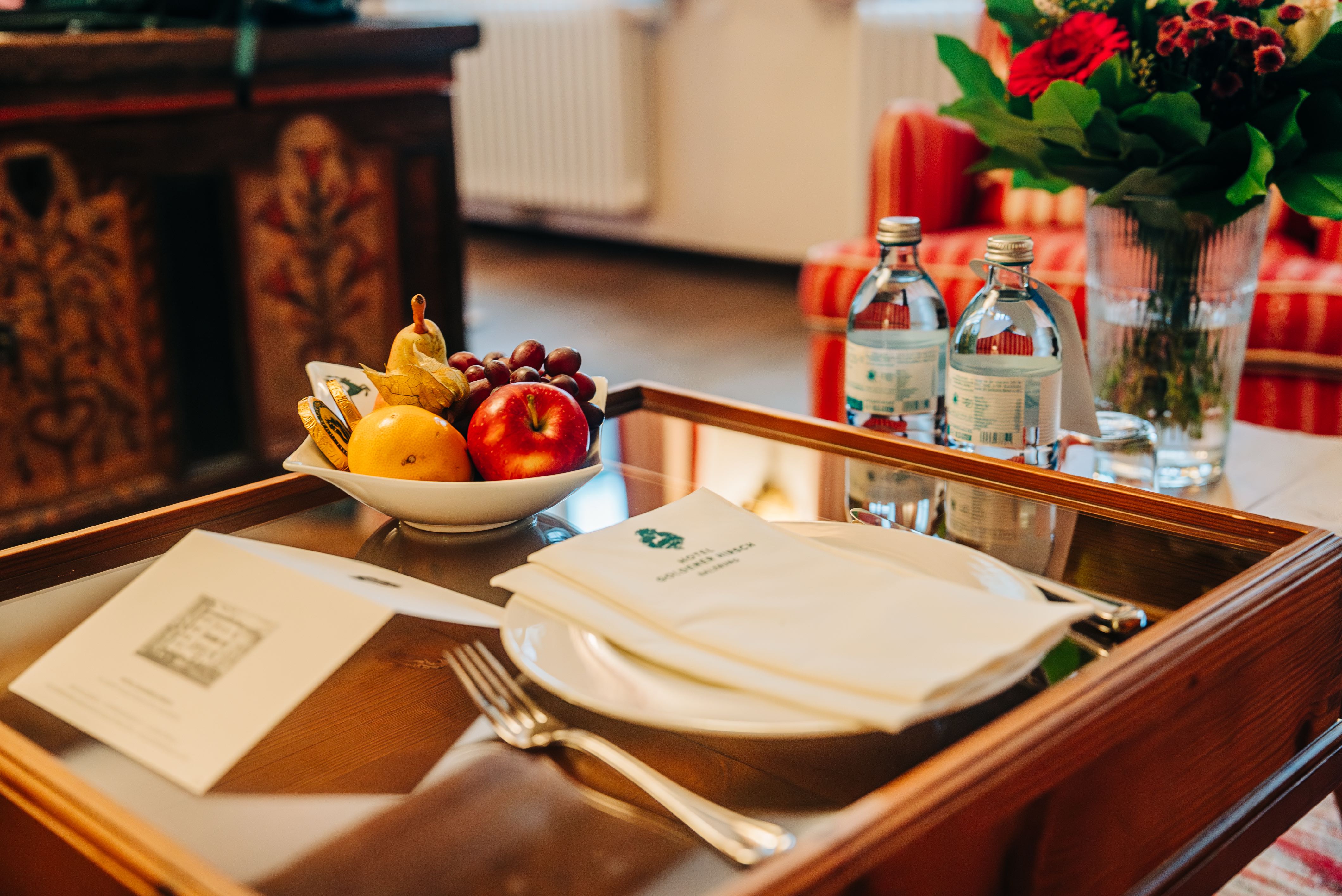 Welcome note, water, fruit, chocolate,s and fresh flowers welcoming us to the Hotel Goldener Hirsch upon arrival