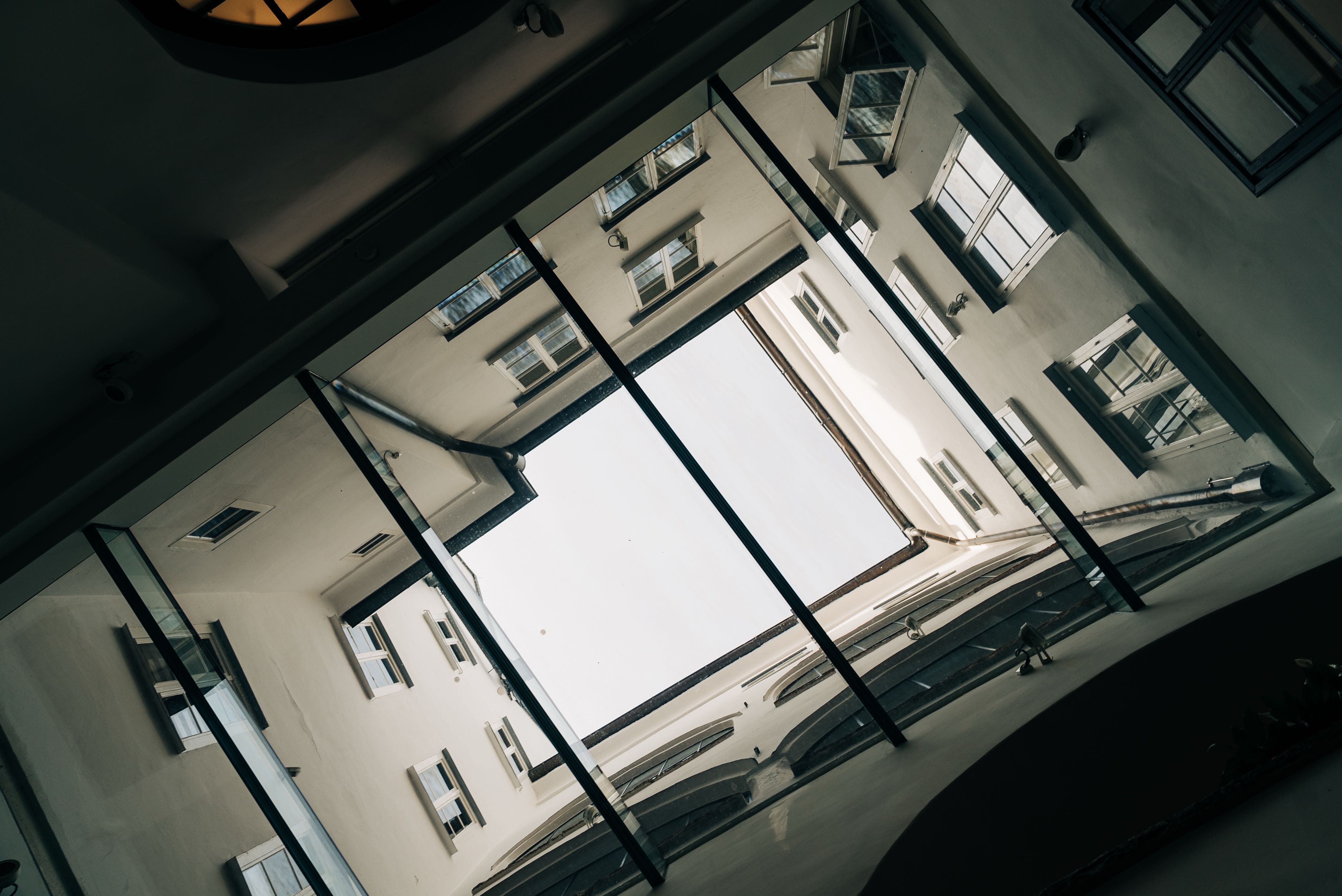 Open glass ceiling looking up above the bar through the Hotel Goldener Hirsch building