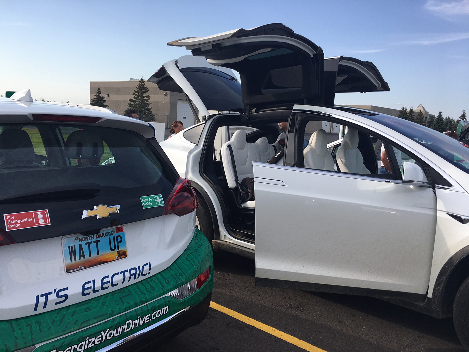 Two electric vehicles in a parking lot during Drive Electric Week.