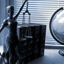 Statue of Justice with scales and books and a globe in the background