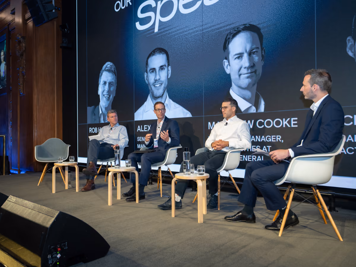 Picture of men giving a panel talk at IR Society's annual conference.