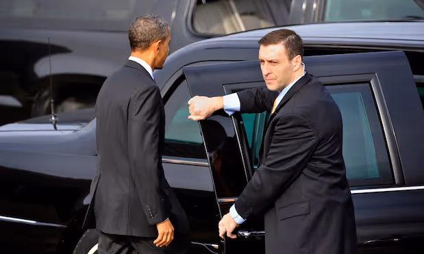 A secret Service agent hold the door open as President Barack Obama returns to his limousine after attending an event honoring the return of United States Forces from Iraq at Joint Base Andrews (Hangar 3) on Tuesday, December 20, 2011. (DOD PHOTO BY GLENN FAWCETT)(Released)