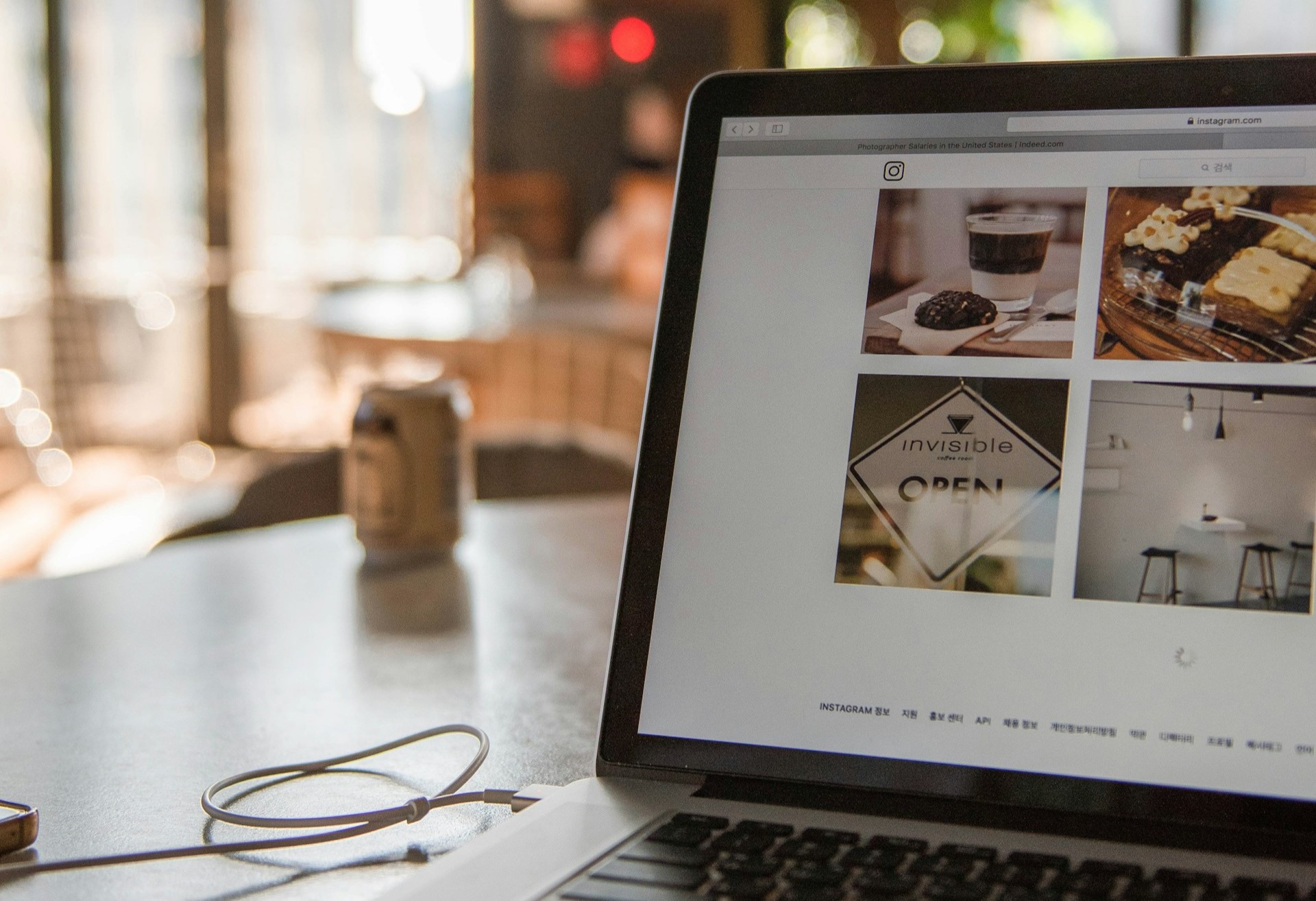 website images open on laptop in sunny cafe