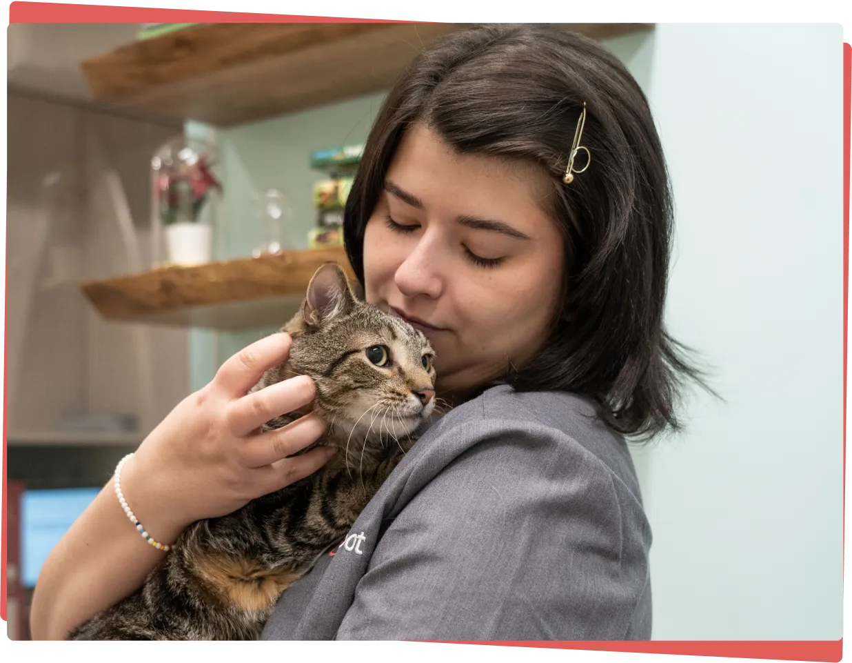 A caring veterinarian comforting a dog by holding its paw while offering a treat.