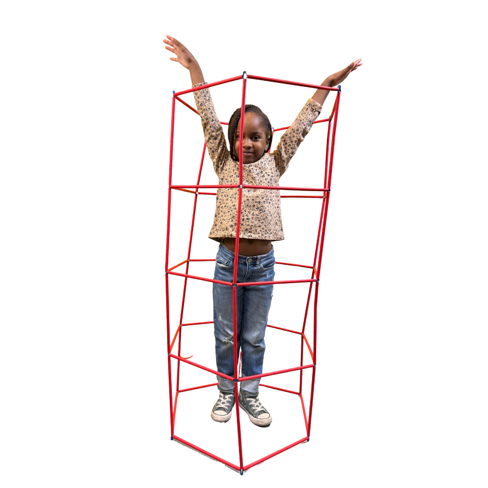 A learner standing inside a tall straw structure with arms raised