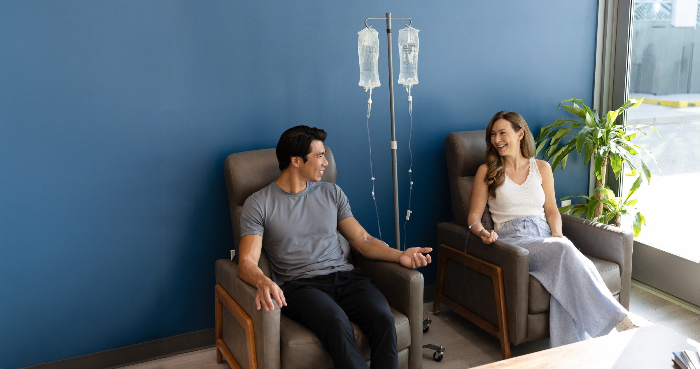 Two members receiving IV drips in a Restore studio