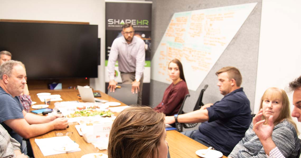 An image of business people sitting behind a table