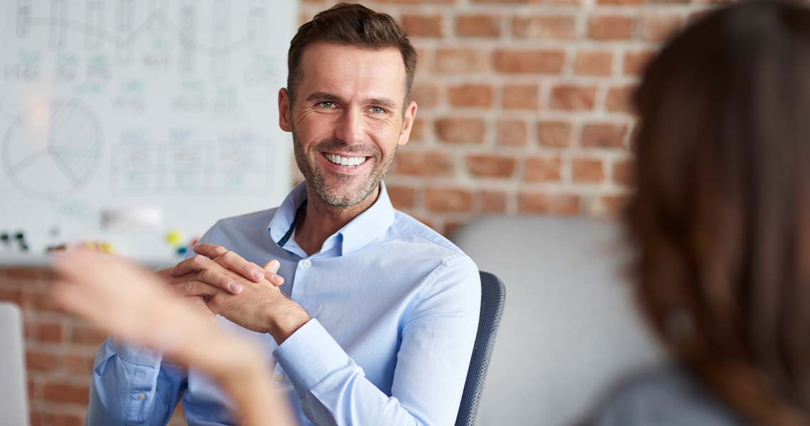 An image of business people sitting behind a table