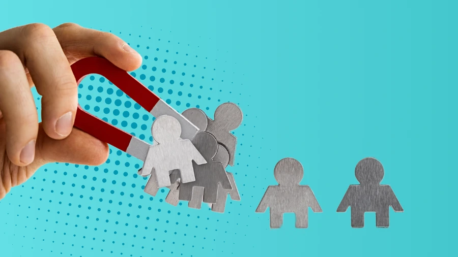 A hand holds a red horseshoe magnet attracting metallic human-shaped figures, while two similar figures remain on a blue background with dotted design elements.