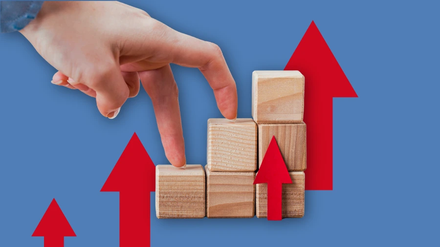Hand walking fingers up wooden blocks with red arrows, symbolizing business growth and step-by-step progress.