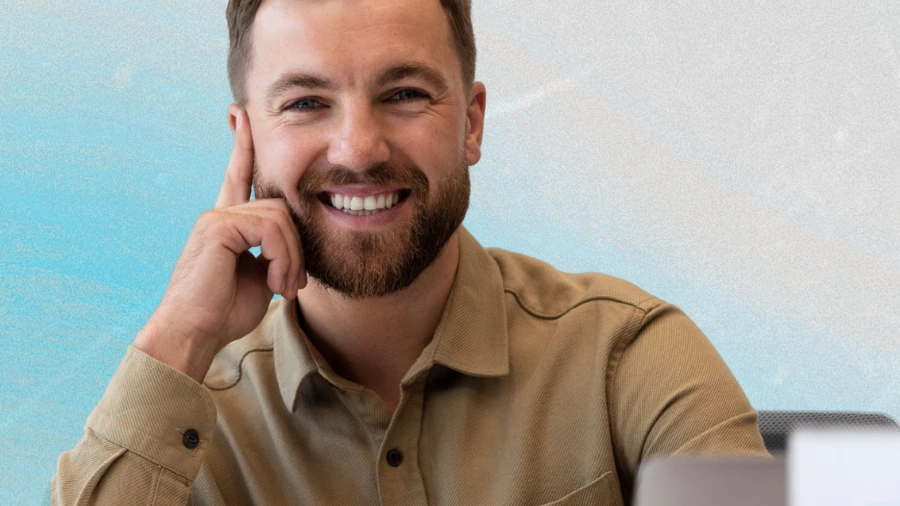 Smiling professional at a desk, illustrating how everyday conversations can turn into organic business leads
