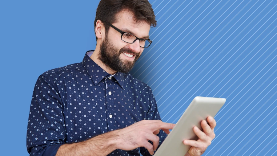 Smiling professional using a tablet, representing business growth and recognizing signs of scaling faster than quality can handle.