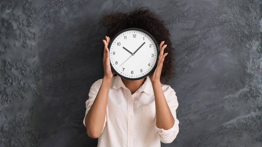 Woman with a clock covering her face