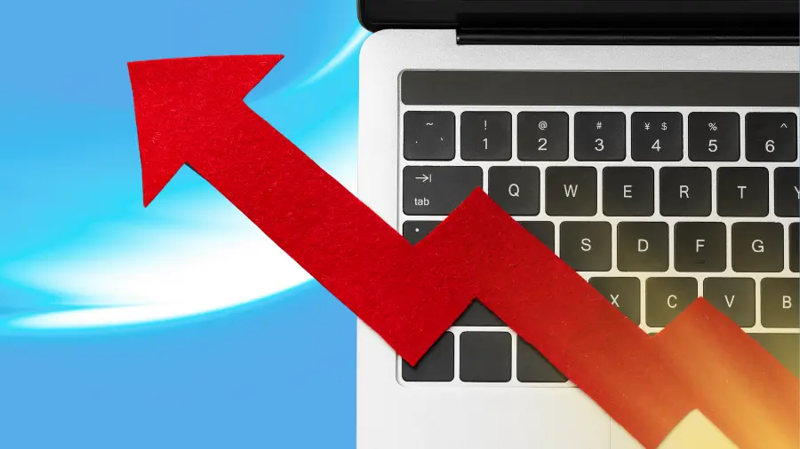 Close-up of a laptop keyboard with a bold red upward arrow, symbolizing business growth, improved performance, and increasing online success.
