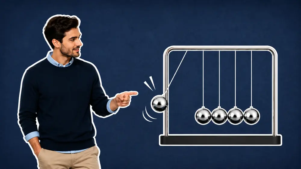 “Businessman pointing toward a Newton’s cradle with one sphere in motion against a textured navy background, symbolizing momentum and business growth.”