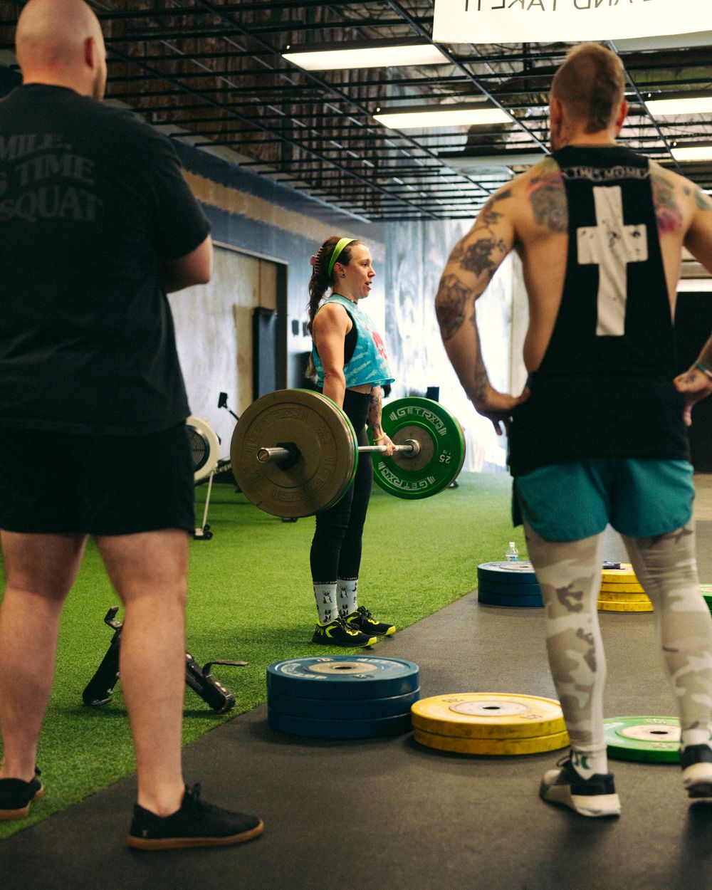 Coach guiding a member through a deadlift