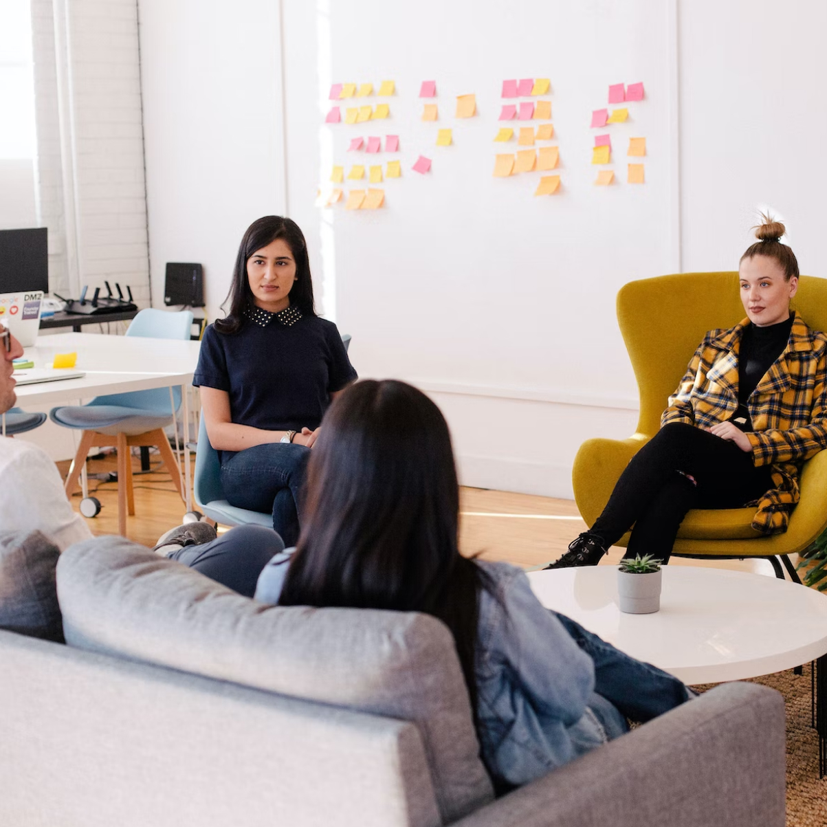 A group of workers sitting around a coffee table.