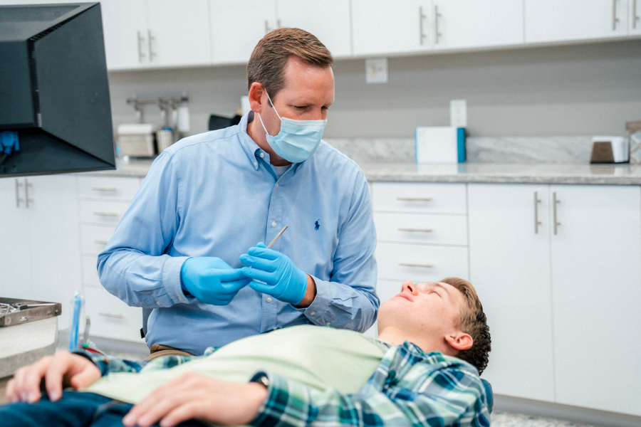 Orthodontist discussing treatment while preparing dental tools for a teen patient at Idaho Orthodontics.
