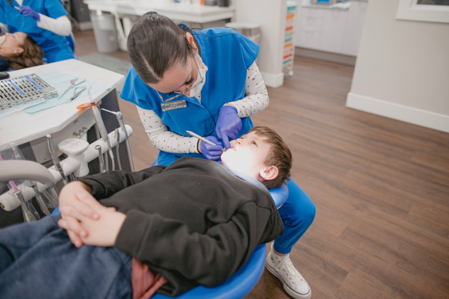 Orthodontic assistant adjusting braces for a young patient during a routine visit at Idaho Orthodontics