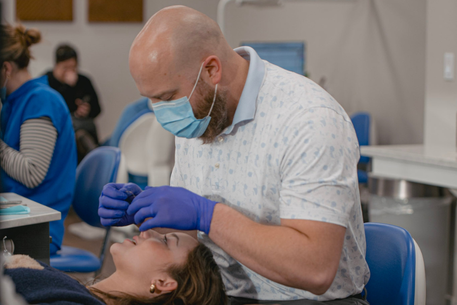 Orthodontist wearing gloves and a face mask examines a patient during an appointment at Idaho Orthodontics.