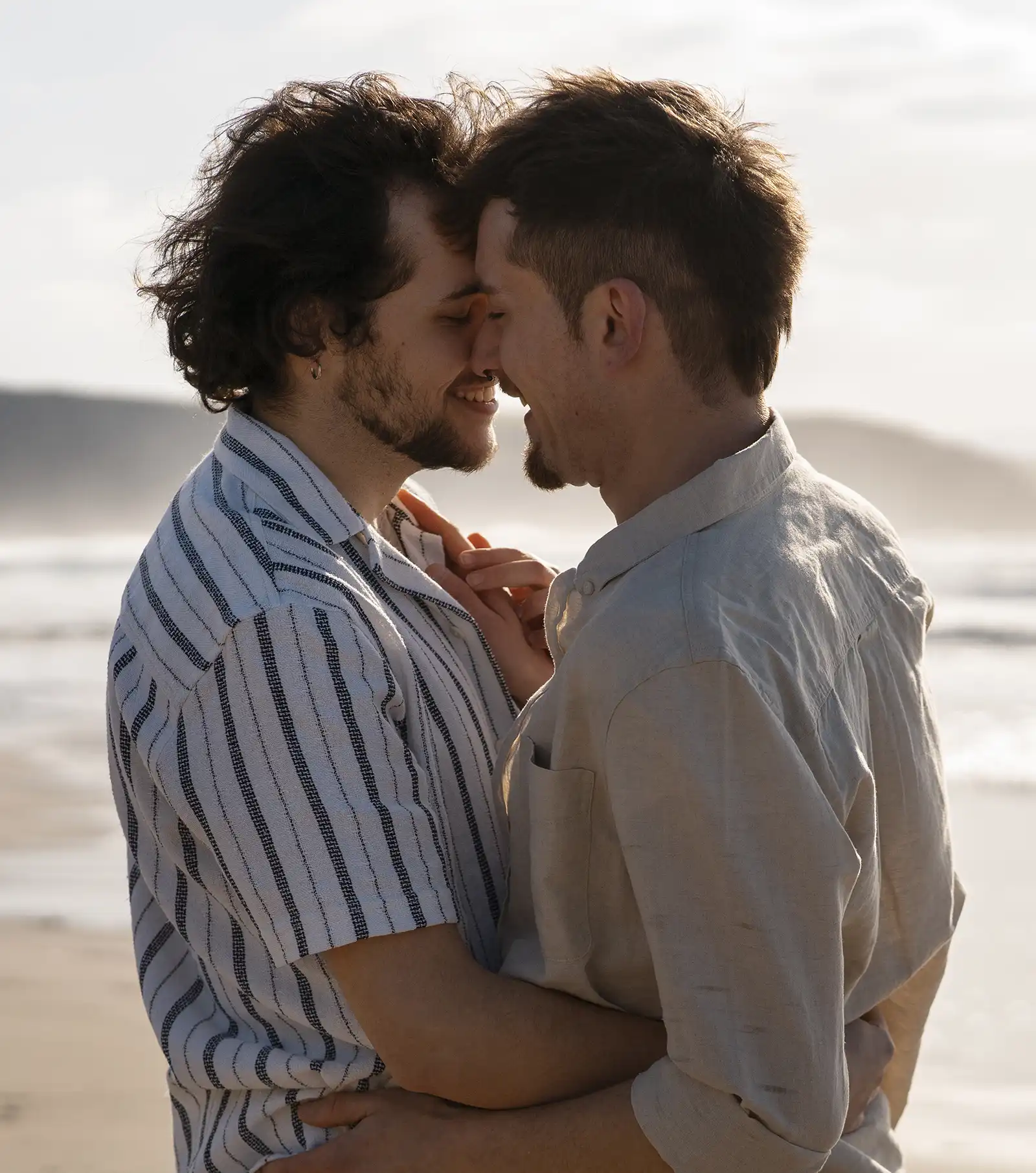 Two men embracing on a sunny beach