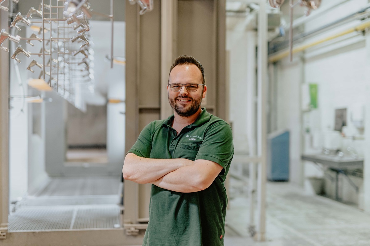 Junger Mann mit Brille in grünem Poloshirt