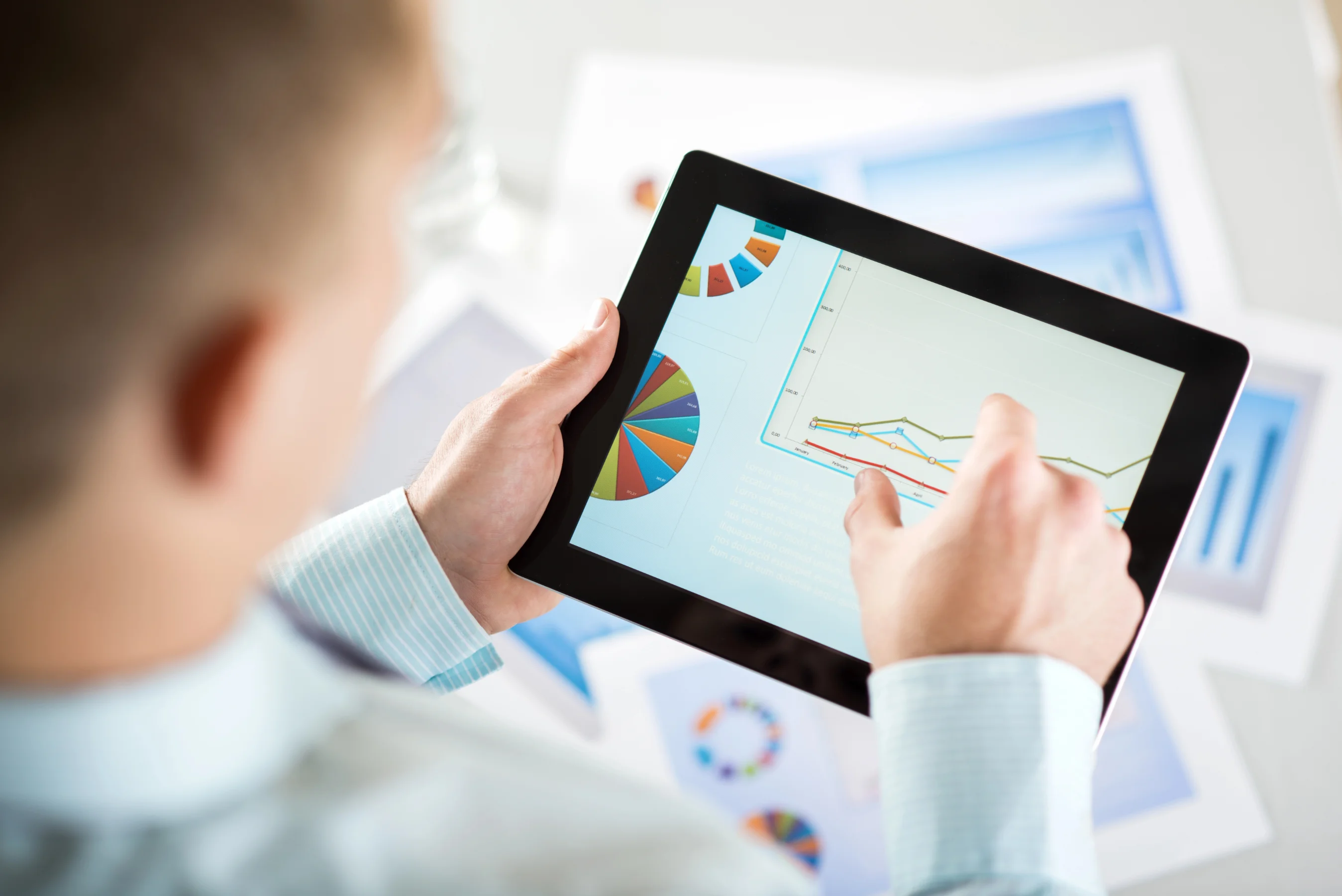 businessman reading charts and graphs on tablet after learning how to scale paid ads profitably