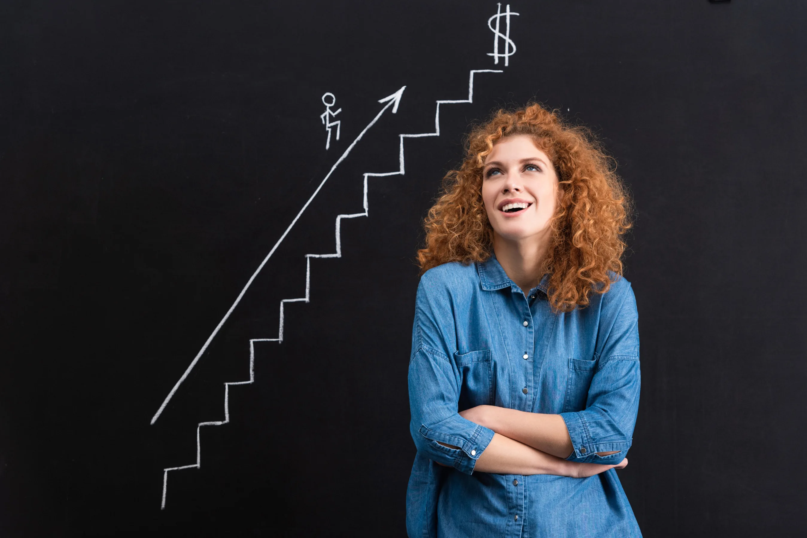 female stands in front of chalkboard that has illustration that represents growth by creative testing framework and paid ads