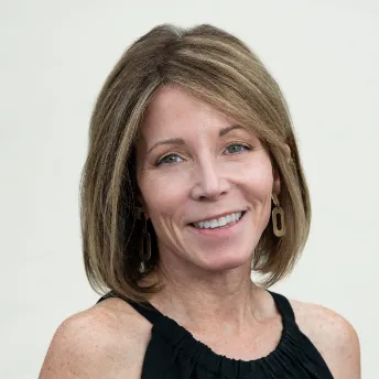 Julie with shoulder-length hair and black top.