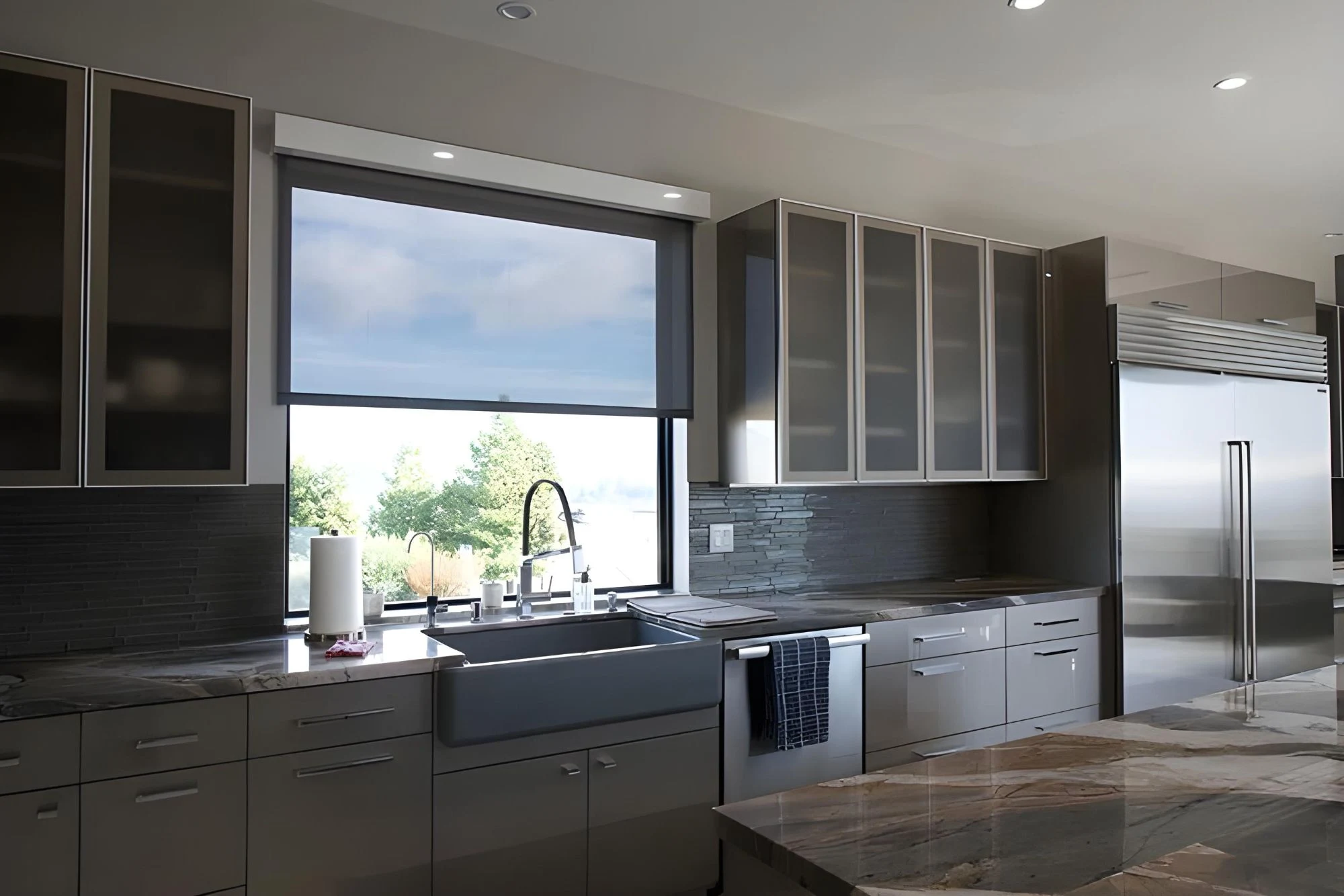 Modern kitchen with a roller shade partially down.