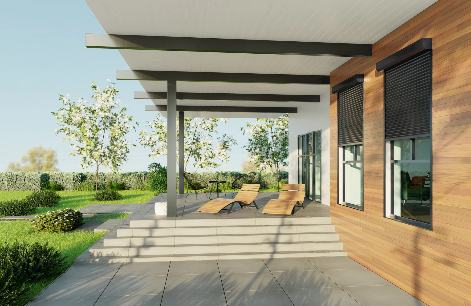 Modern patio with wooden lounge chairs, metal beams, and a garden with white flowering trees.