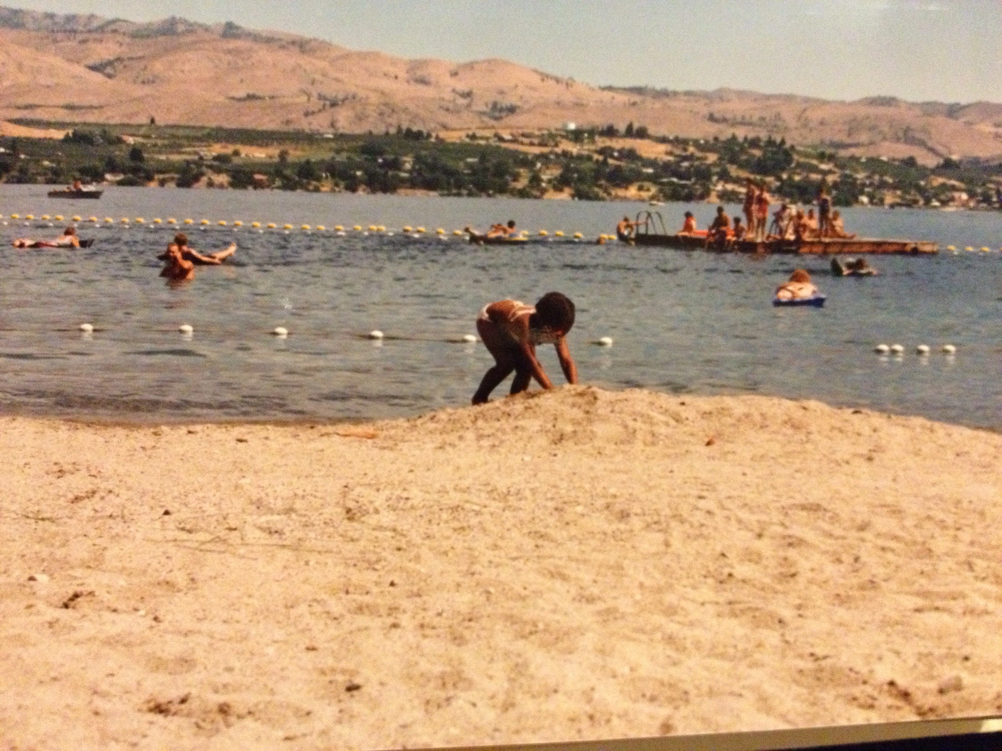A young child playing in the beach sand