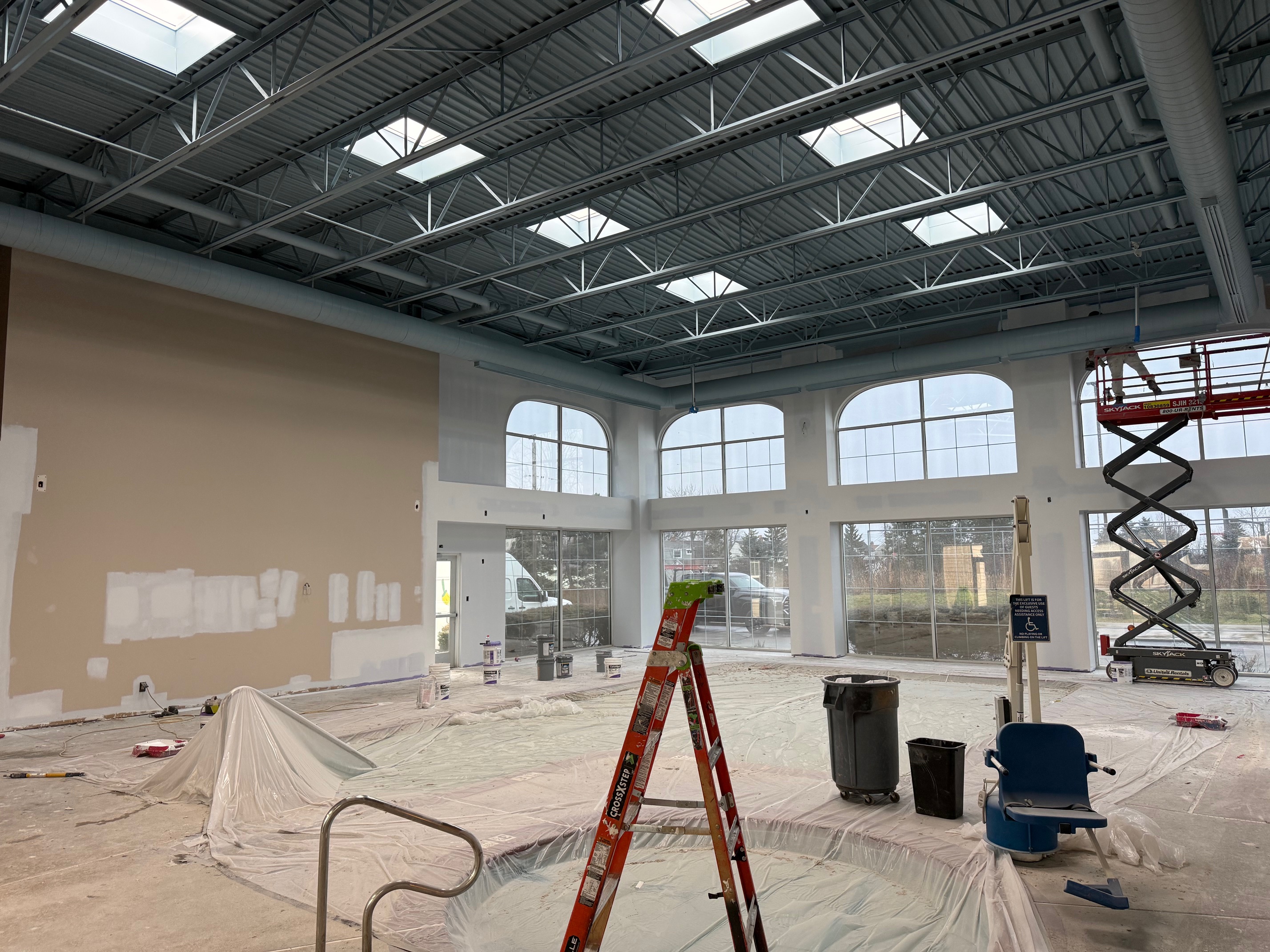 Homewood Suites pool room before repainting, showing patchy beige walls and prep work in progress.