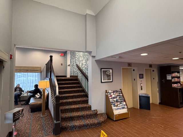 Renovated lobby at Sleep Inn Amherst with freshly painted walls and improved lighting around stairwell area.