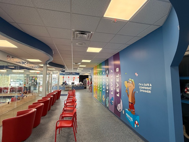 Vibrant interior wall mural highlighting swim levels at Aqua-Tots Swim School in Amherst.