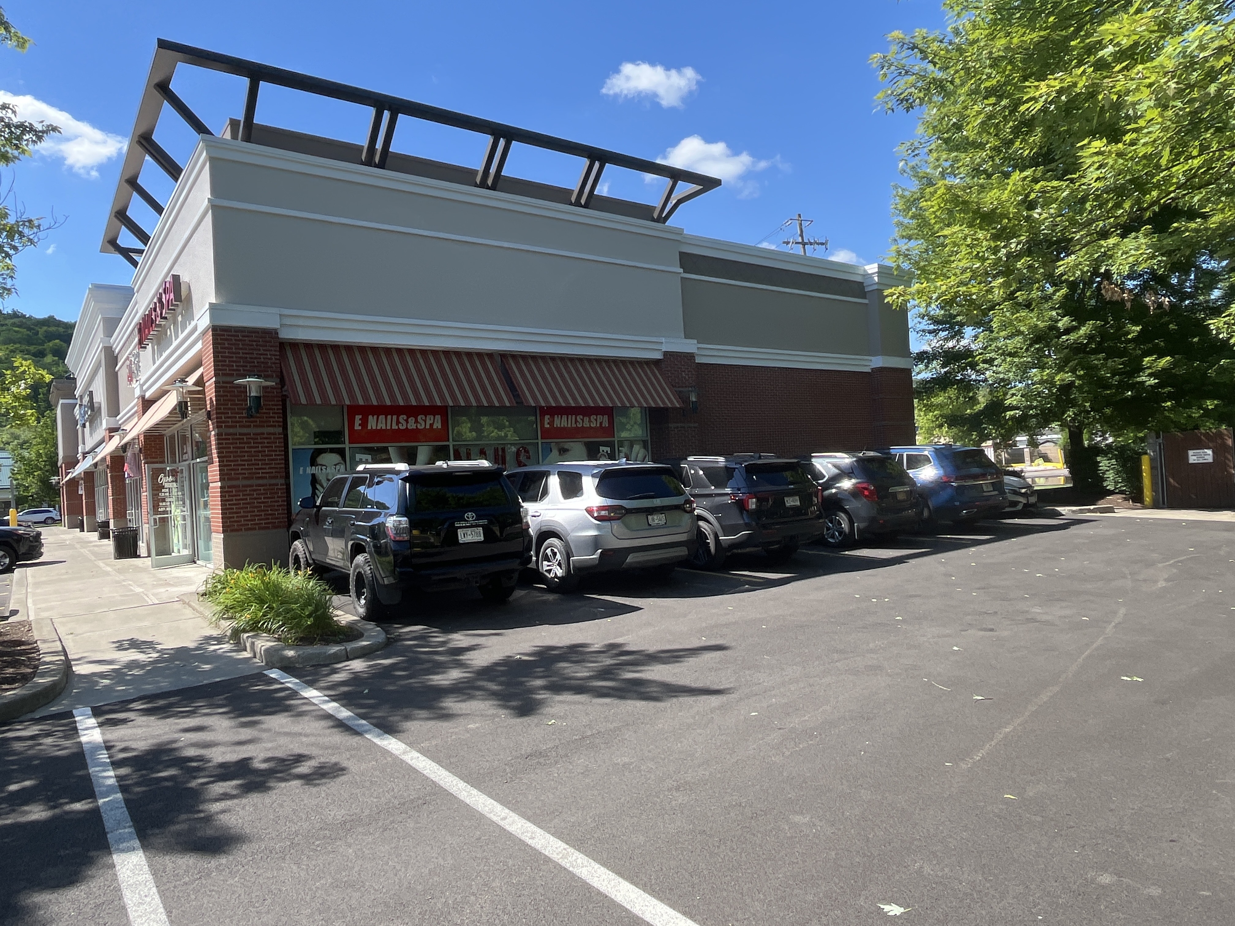 Side view of retail plaza showing newly painted EIFS, coping, and architectural trim in Ithaca, NY