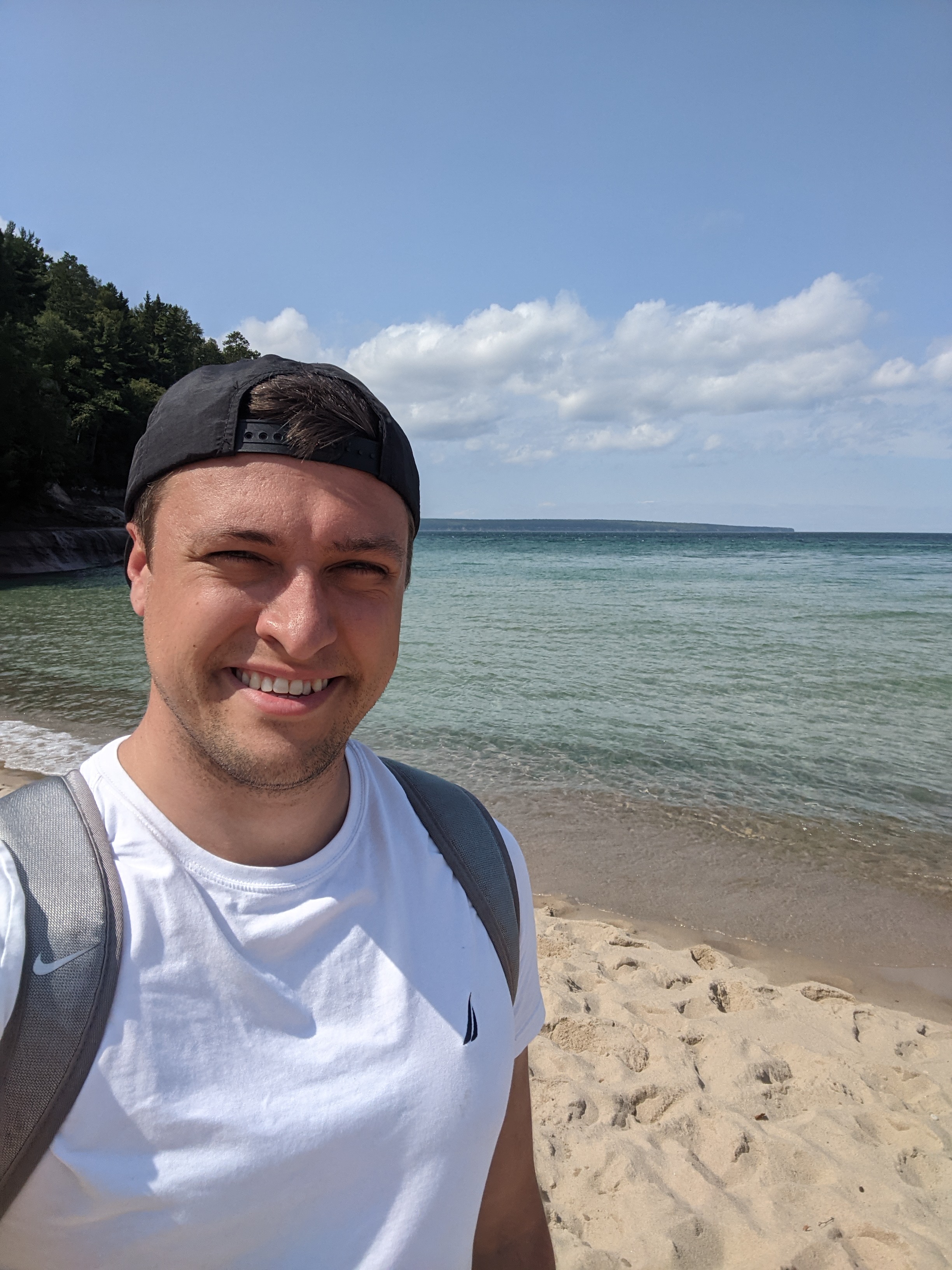 Dane standing on a beach on one of the great lakes. 
