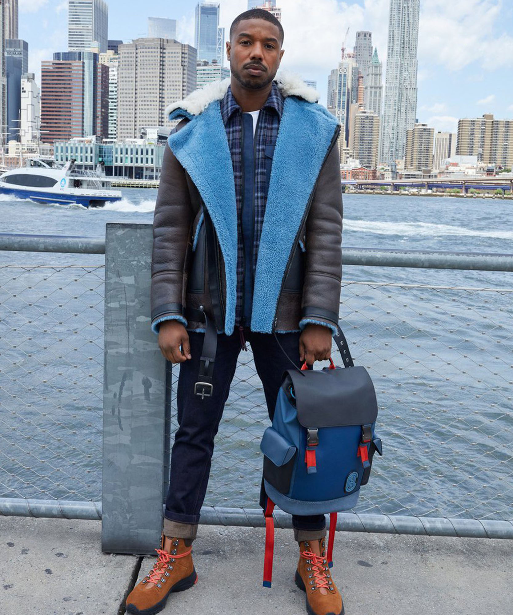 a photo of male model holding backpack with a city background