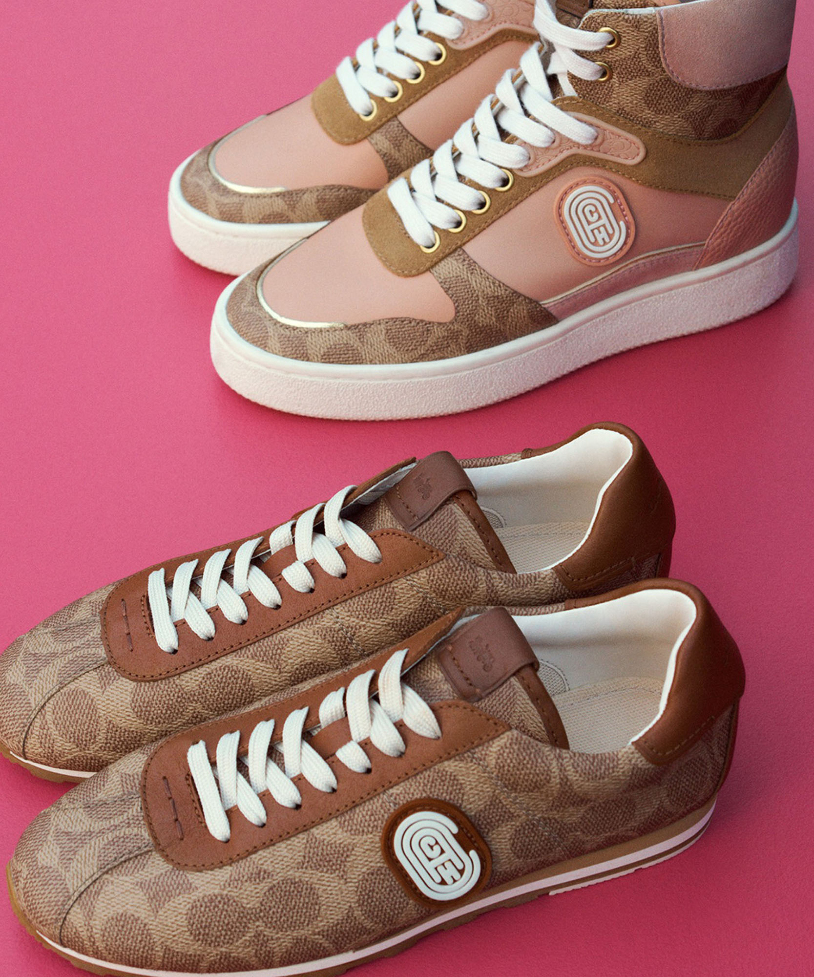a photo of to pair of brown sneakers one low top one high top both with coach logo and a pink background