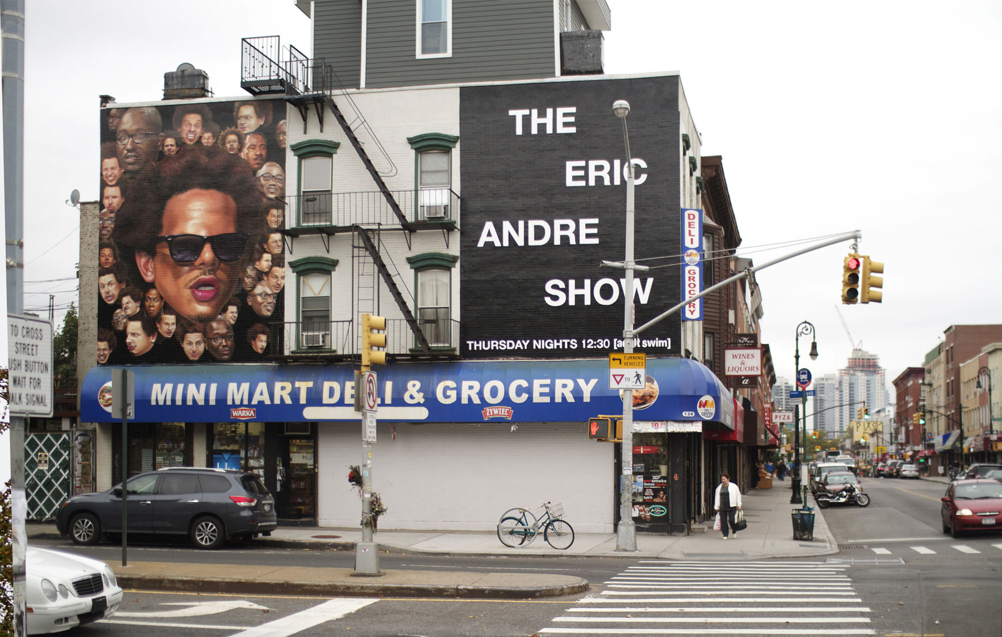 wall art of on the side of a building with eric andres face surrounded by other little faces and a text that reads the eric endre show on the opposite side