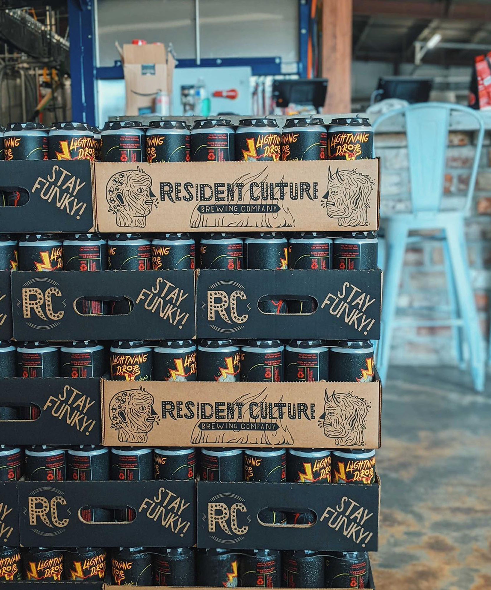 a photo of canned beverages inside a cardboard box with the resident culture logo on the side