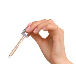 Hand holding a topical minoxidil serum dropper