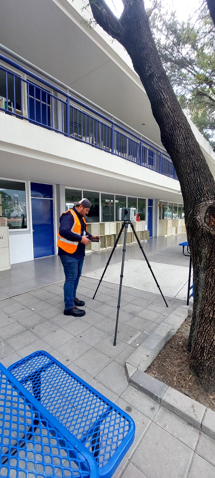 Técnico revisando parámetros de escaneo frente a fachada con barandales del Colegio Irlandés — levantamiento de condiciones existentes para fabricación de lámina perforada