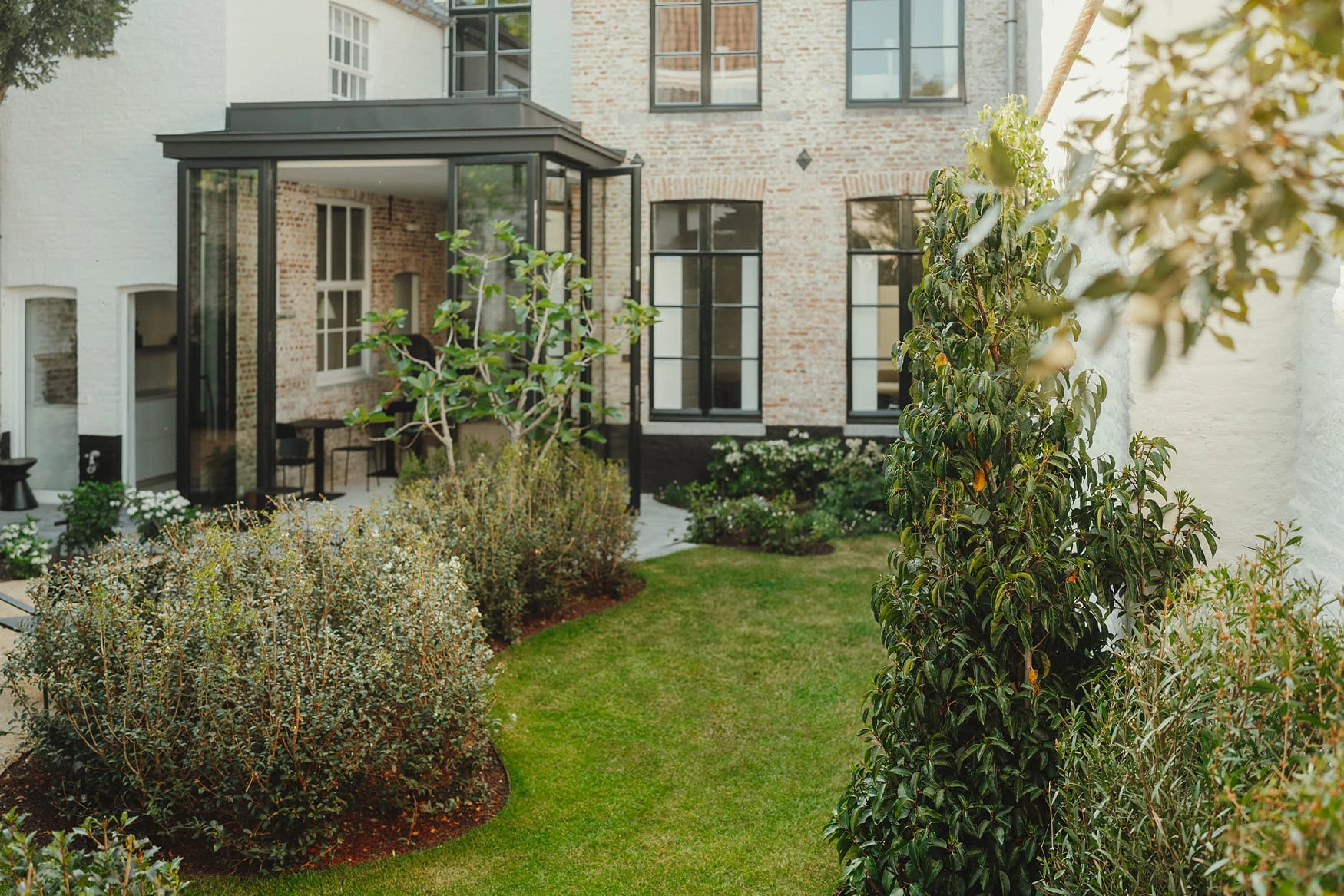 Zicht vanuit kamer Azzuro bij Everelmus. Met zicht op de tuin die werd ontworpen door Linears landscapers.