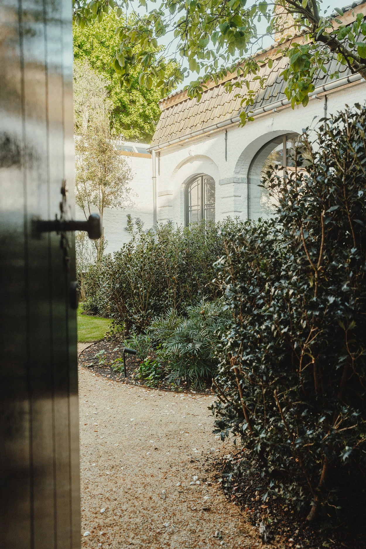 Sfeerbeeld via de zij-ingang van Everelmus Brugge. Waar Guy Stockmans met Linears landscapers de tuin ontwierp.