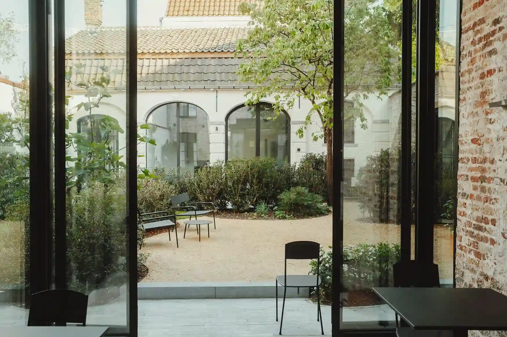Zicht op de tuin vanuit de ontbijtruimte bij Everelmus Brugge.