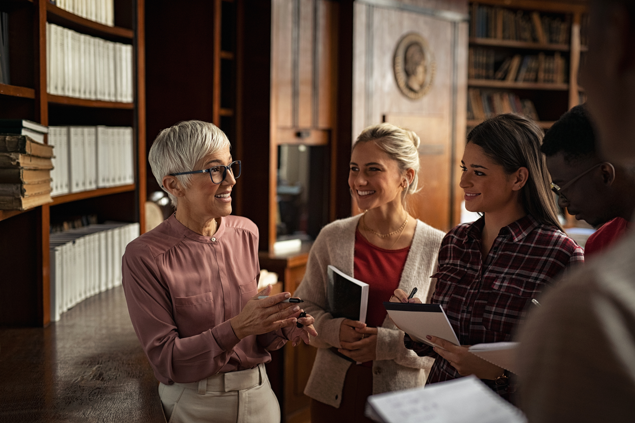 Teaching faculty lecturing a group of study abroad students in a library